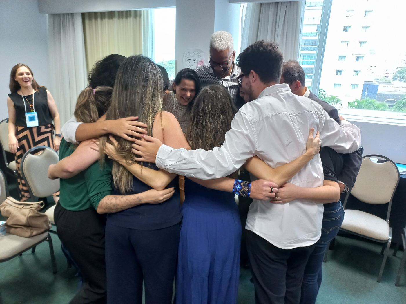 Participantes em um abraço coletivo ao final de uma dinâmica